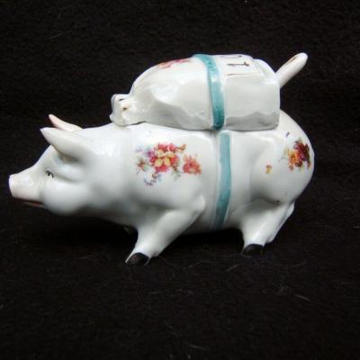 Moutardier en porcelaine figurant un cochon portant un sac sur son dos Fin XIX